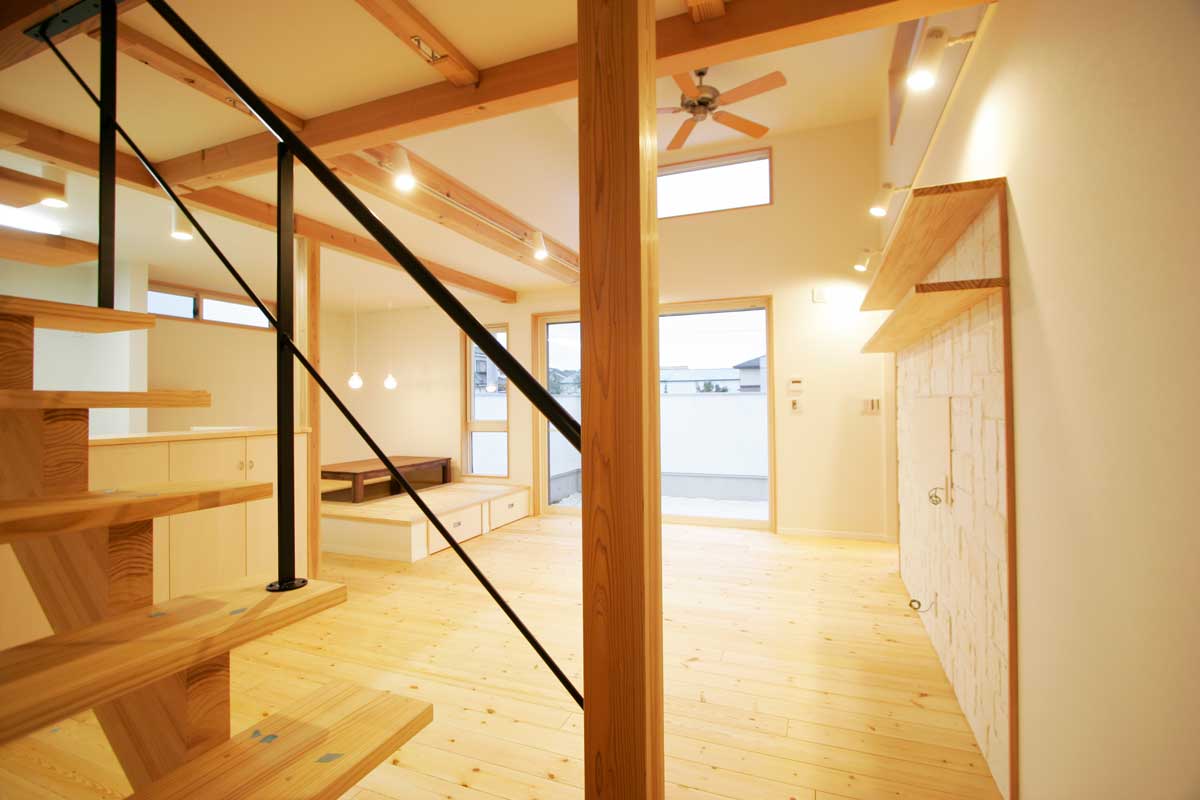 吹抜け空間と無垢材が印象的な白いデザイン住宅