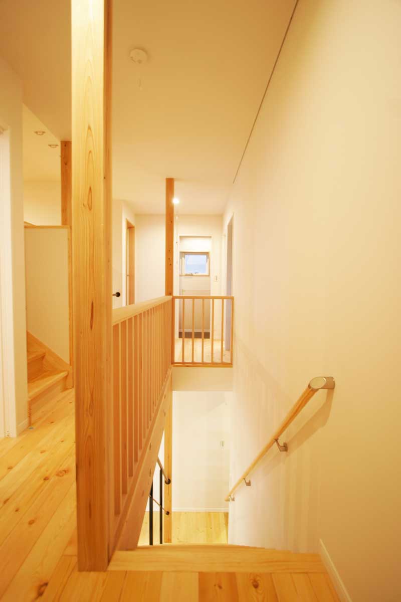 吹抜け空間と無垢材が印象的な白いデザイン住宅