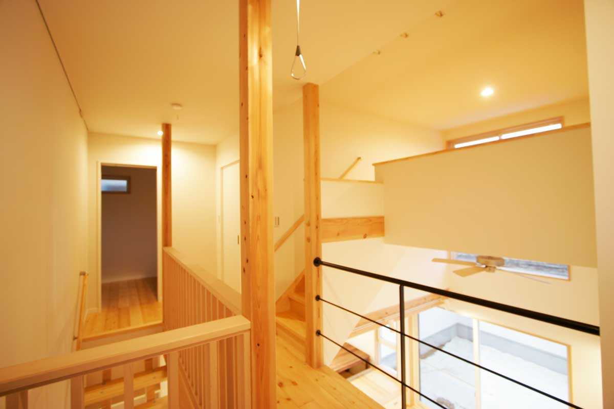 吹抜け空間と無垢材が印象的な白いデザイン住宅