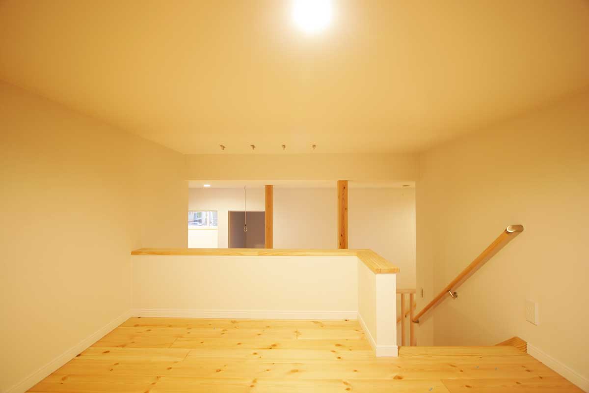 吹抜け空間と無垢材が印象的な白いデザイン住宅