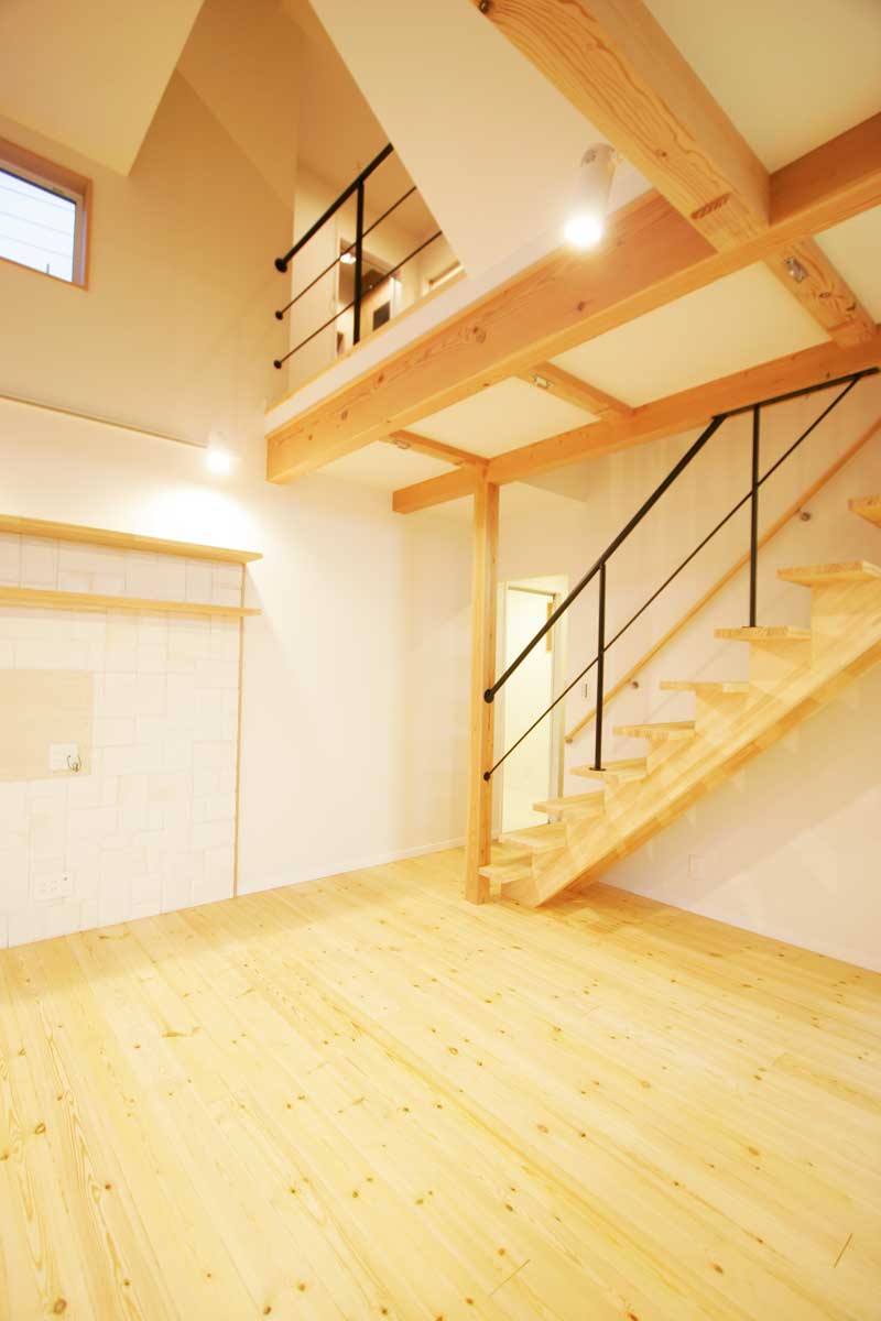 吹抜け空間と無垢材が印象的な白いデザイン住宅