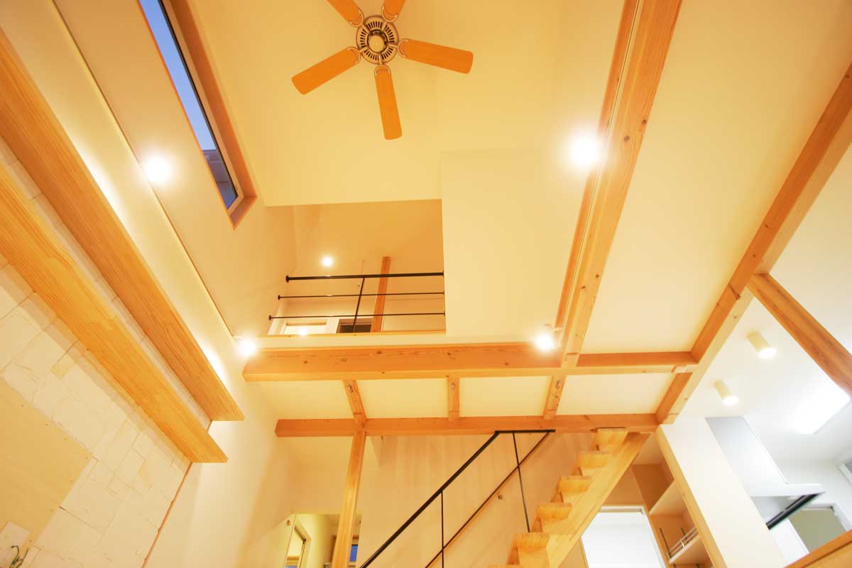 吹抜け空間と無垢材が印象的な白いデザイン住宅