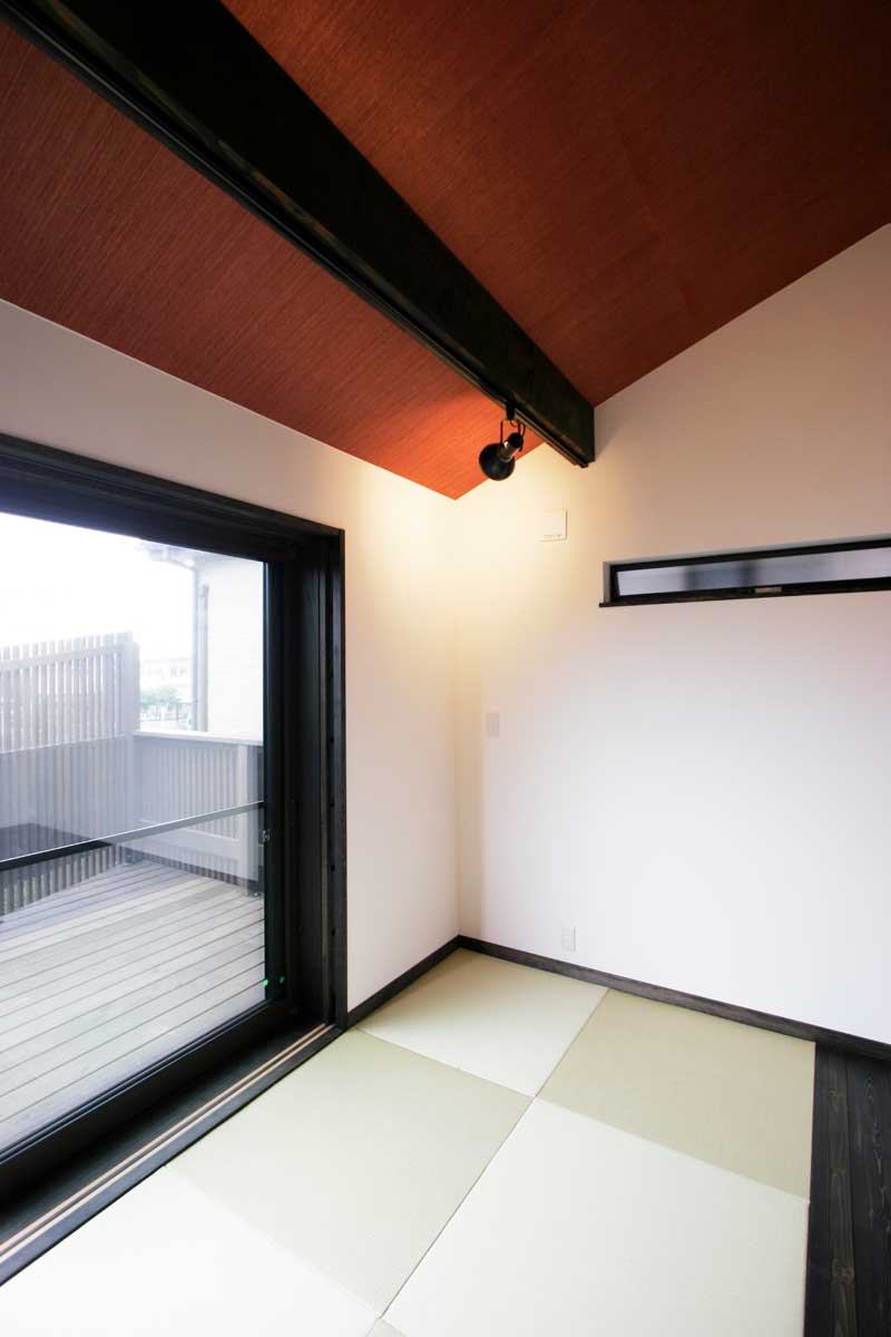 木調格子の柵が印象的な朱と黒の和モダン住宅