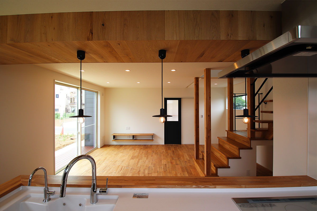 造作カウンターキッチンとウッドデッキのあるシンプルモダンな白い家