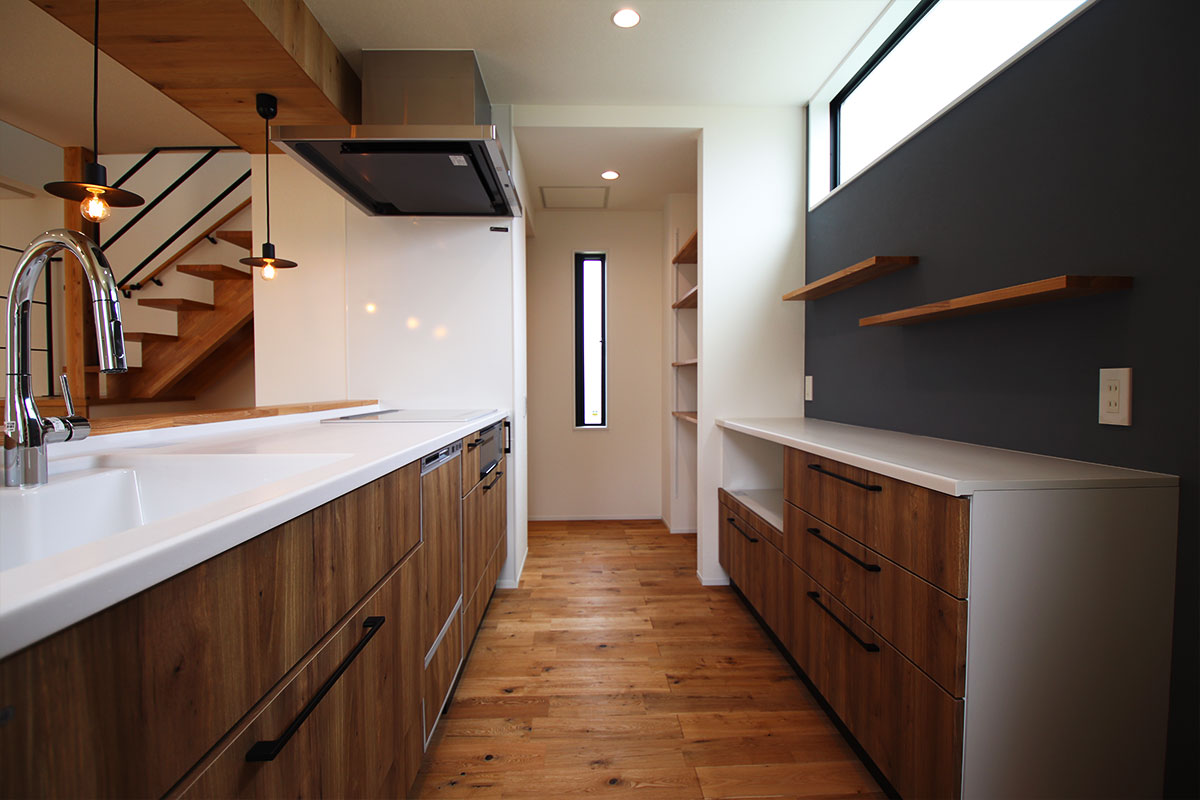 造作カウンターキッチンとウッドデッキのあるシンプルモダンな白い家